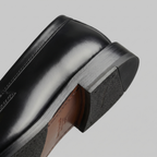 Sorte penny loafers til mænd med blank finish og flad sål