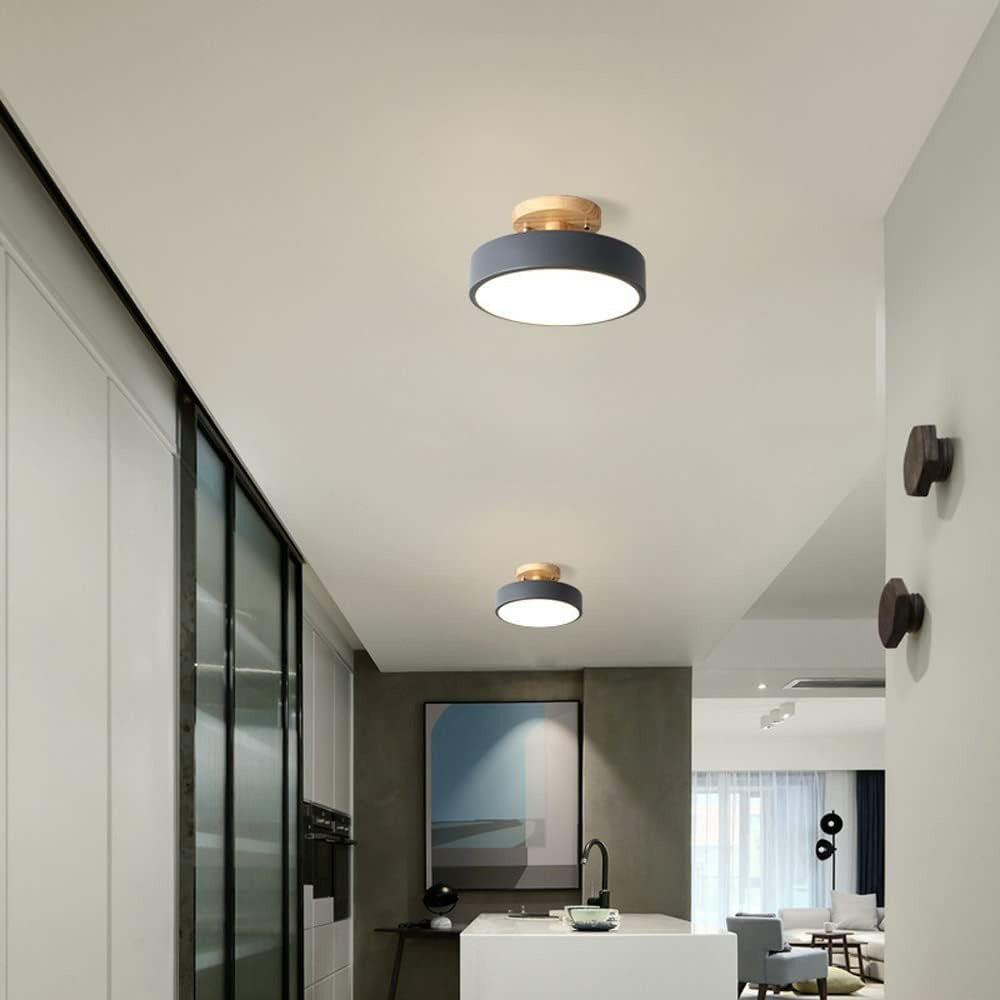 Dwie zielone okrągłe lampy sufitowe LED z jasnymi drewnianymi podstawami